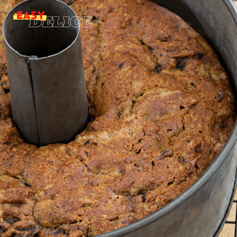 Gâteau moelleux aux dattes découpé, garni de noix concassées et servi avec un thé.