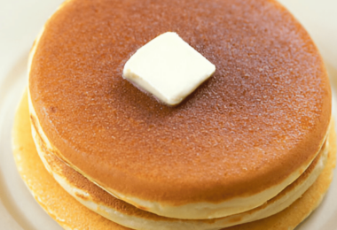 Pile de crêpes dorées façon McDonalds avec du beurre fondant et du sirop d'érable.