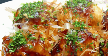 Assiette de Takoyakis traditionnels garnis de sauce takoyaki, mayonnaise et flocons de bonite