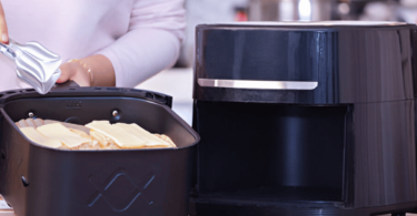 Airfryer moderne sur un comptoir de cuisine, rempli de frites dorées et croquantes.