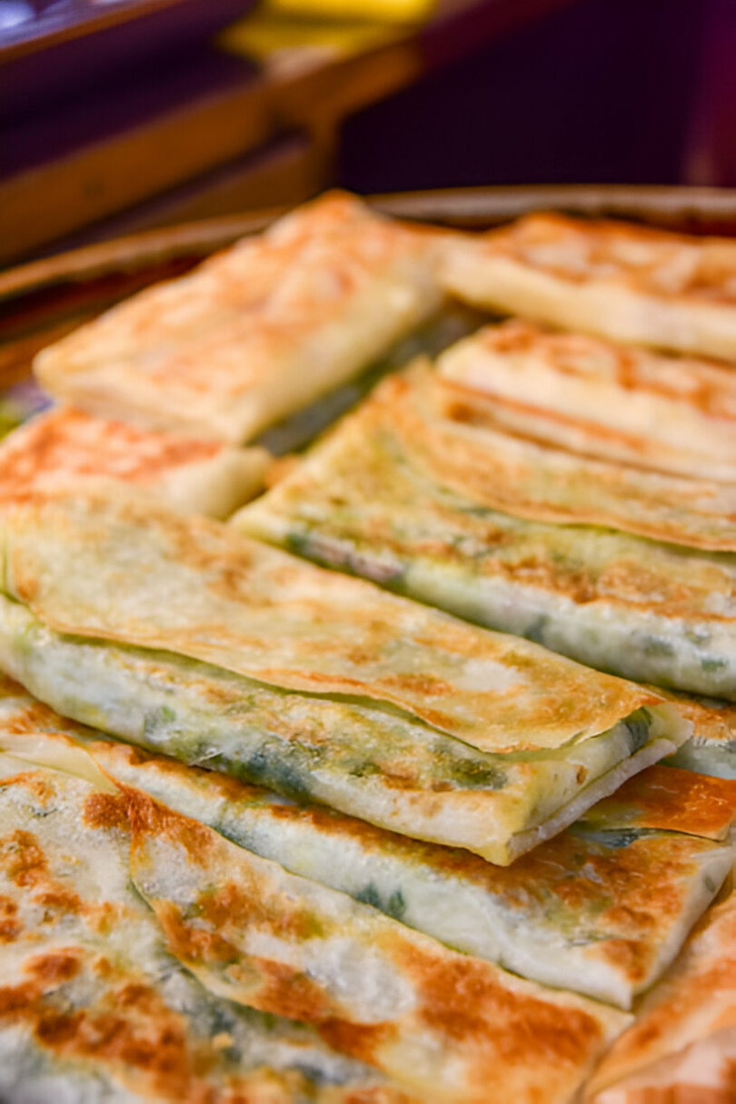 Galettes salées dorées et croustillantes, garnies d'oignon vert et de fromage fondu