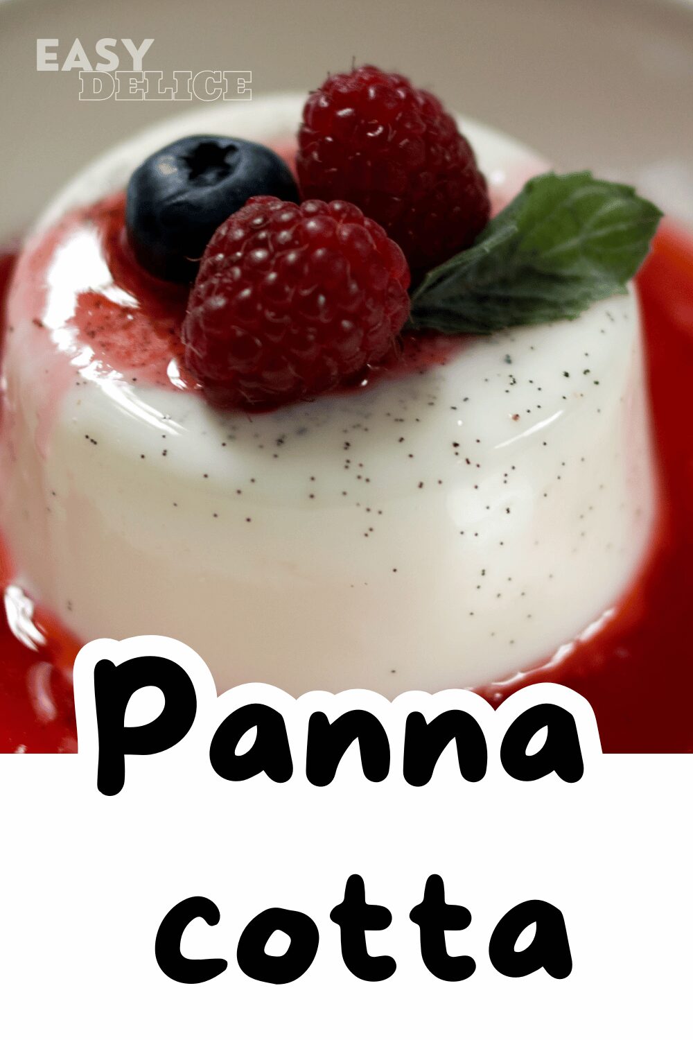 Panna cotta onctueuse dans une verrine, nappée de coulis de fruits rouges et décorée avec une feuille de menthe.