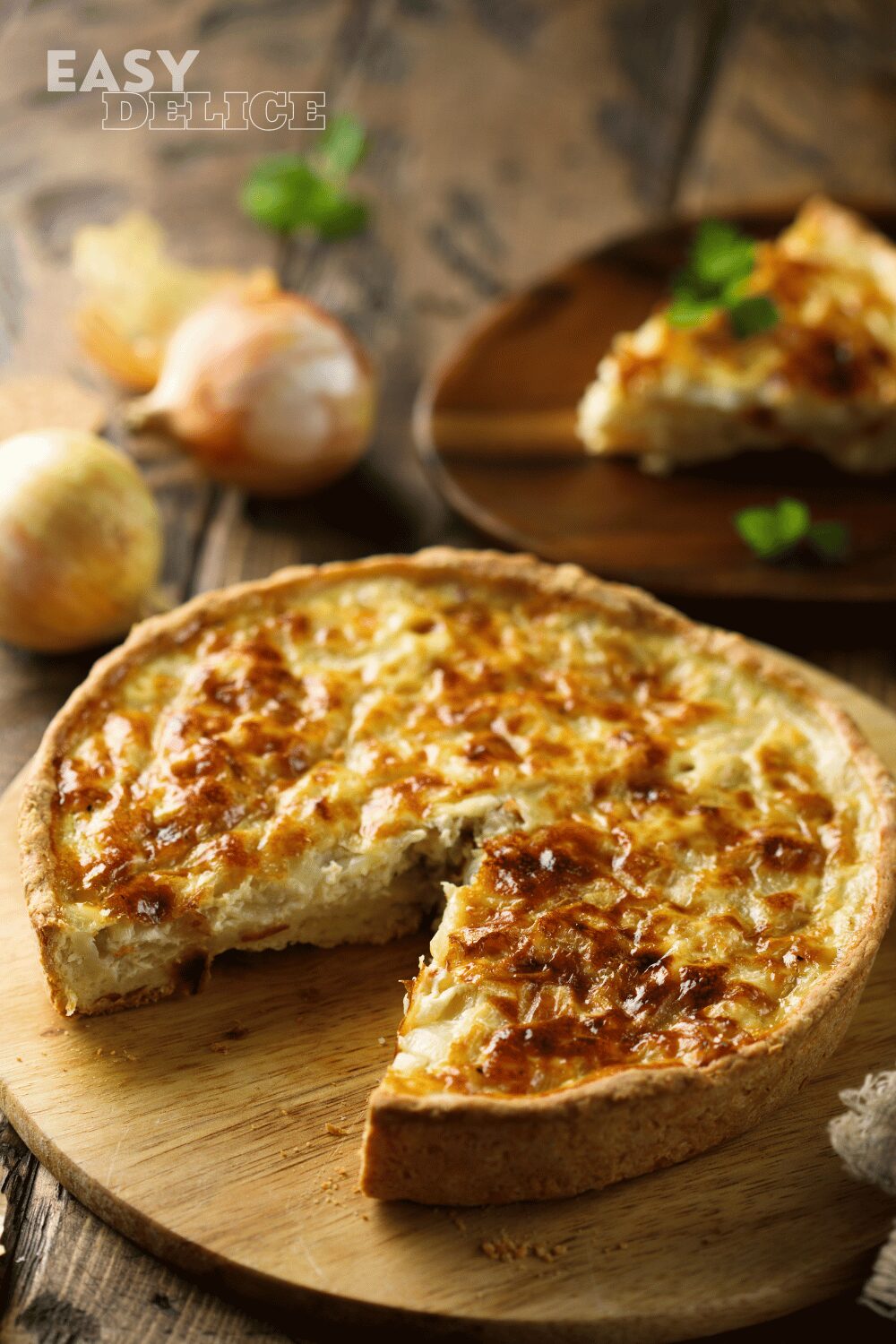 Quiche aux oignons dorée et fondante, servie avec une salade verte.