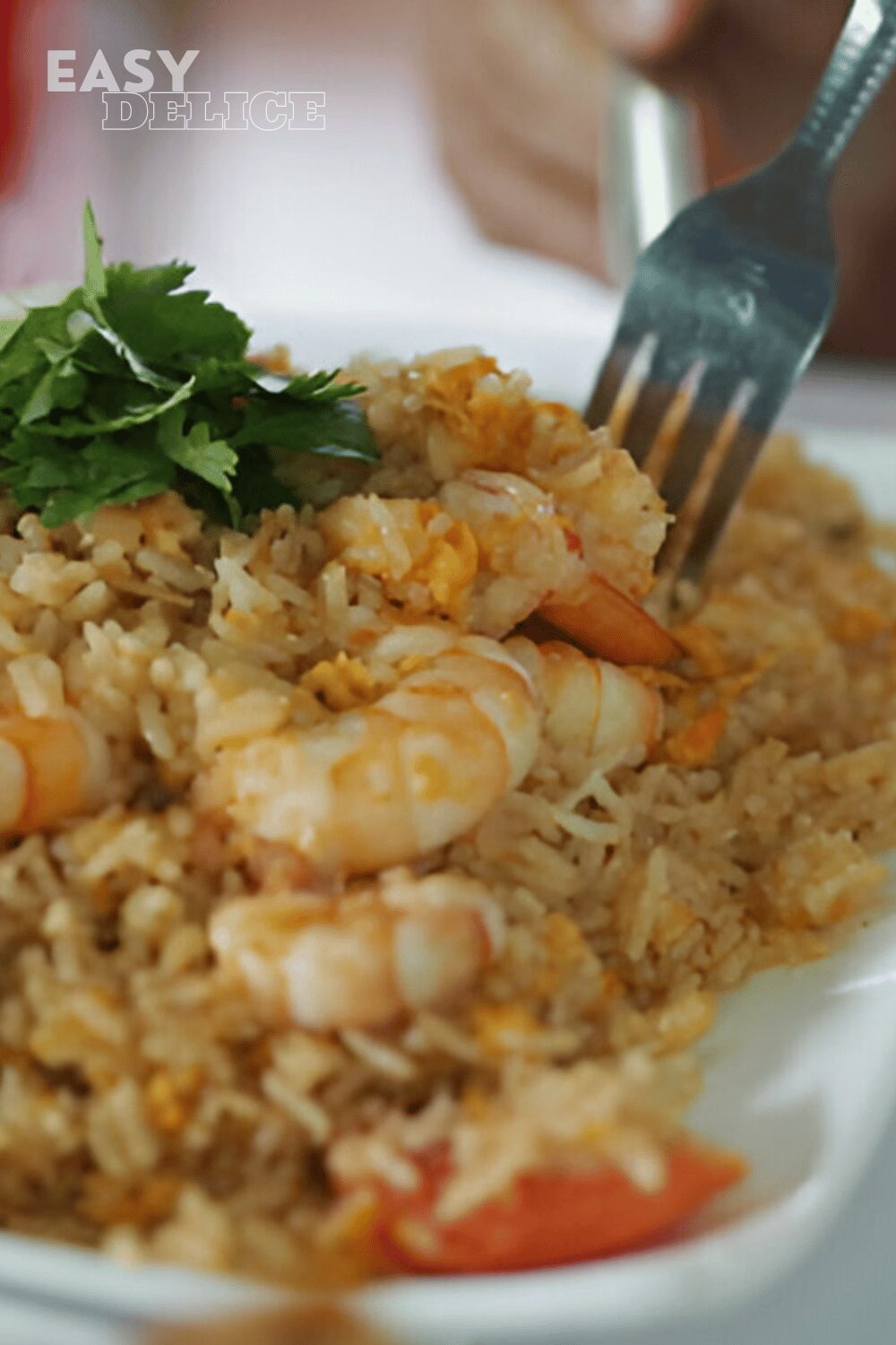 Riz sauté thaï aux légumes et crevettes servi dans un bol avec des herbes fraîches.