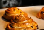 Pains aux raisins maison dorés et feuilletés, garnis de crème pâtissière et raisins.