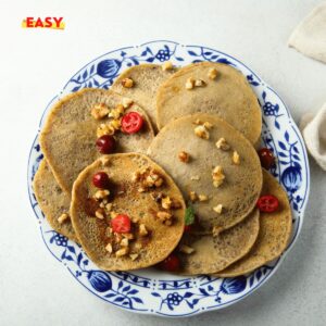 Pancakes à la farine de sarrasin dorés, empilés avec du miel et des fruits frais.