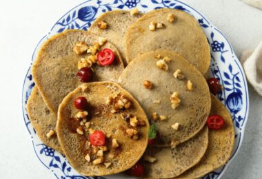 Pancakes à la farine de sarrasin dorés, empilés avec du miel et des fruits frais.