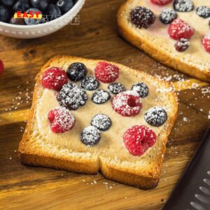 Custard toast doré et garni de fruits frais, servi sur une assiette.