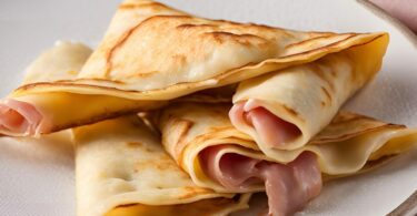 Crêpes au jambon et béchamel croustillantes, servies dorées sur une assiette, accompagnées d’une salade verte.