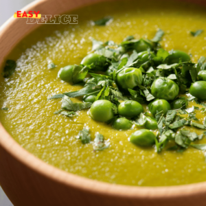 Soupe de petits pois onctueuse servie dans un bol avec croûtons et menthe fraîche