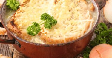 Soupe à l’oignon gratinée servie avec du fromage fondu et des croûtons dorés.