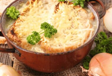 Soupe à l’oignon gratinée servie avec du fromage fondu et des croûtons dorés.