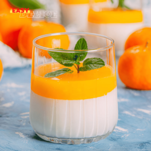 Mousse aux clémentines servie en verrine avec zestes et feuilles de menthe.