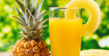 Jus d’ananas frais dans un verre, décoré d’une tranche d’ananas et de glaçons, une boisson tropicale et rafraîchissante