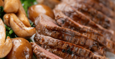 Rôti de bœuf cuit à l’airfryer, prêt à être tranché et servi avec des légumes rôtis.