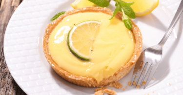 Tarte au citron moelleuse et acidulée cuite à l’airfryer, prête à être dégustée avec une touche de sucre glace.