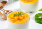 Verrine de panna cotta à la mangue, surmontée de purée de mangue fraîche, décorée de feuilles de menthe.