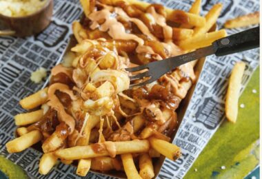 Poutine végétalienne avec frites croustillantes, sauce brune et fromage végétal fondant.