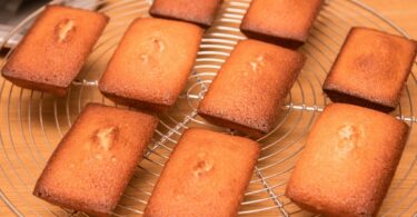 Financiers à l'orange moelleux et dorés, parsemés de zestes d’orange.