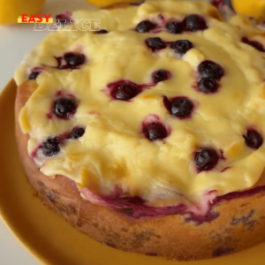 Cake au citron et aux myrtilles, doré et moelleux, avec une crème au citron onctueuse.