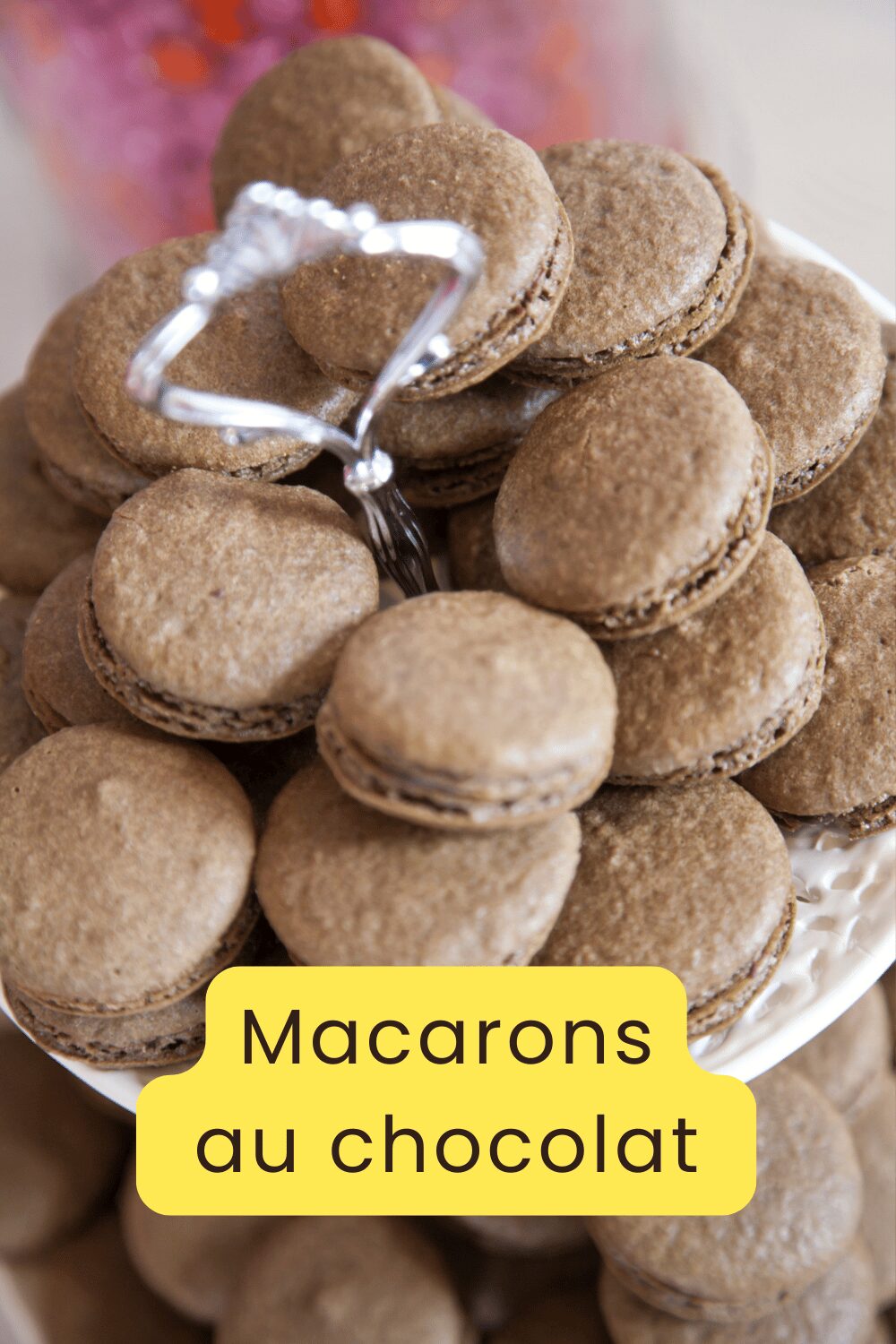 Macarons au chocolat avec ganache brillante empilés sur une assiette blanche