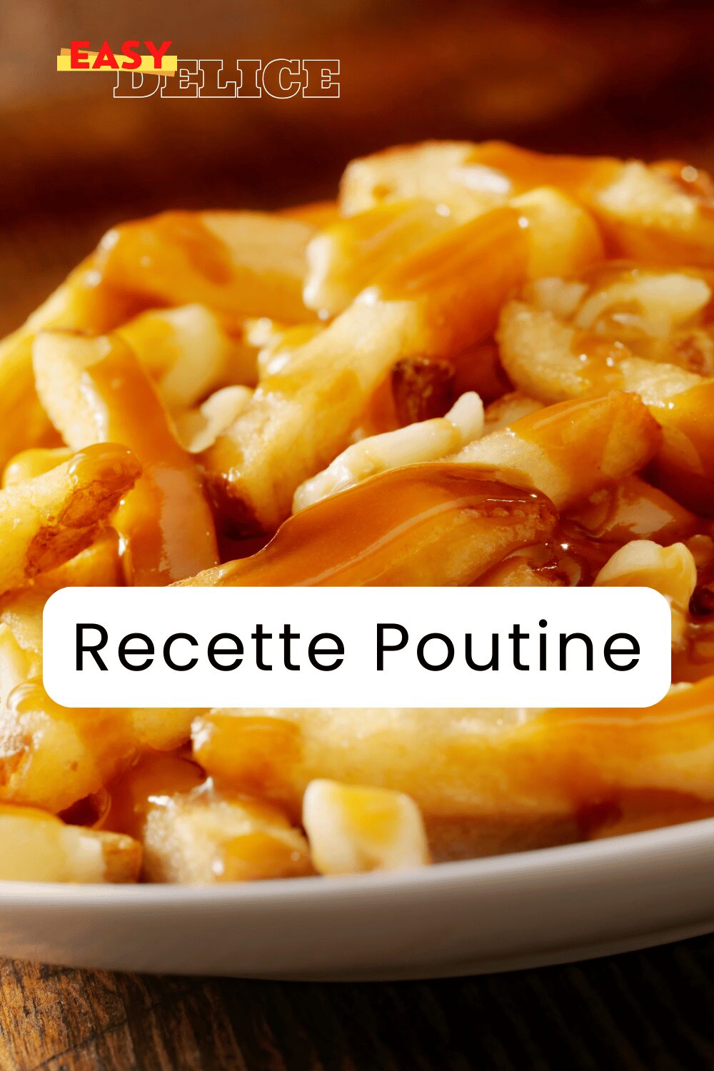 Poutine québécoise servie dans une assiette avec des frites dorées, du fromage en grains et une sauce brune nappante.