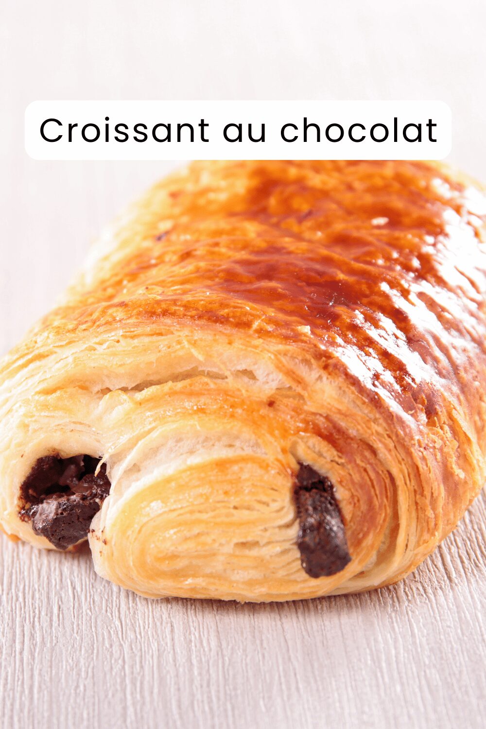 Croissant au chocolat doré et croustillant, garni de chocolat fondant.