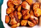 Pilons de poulet dorés avec pommes de terre rôties et herbes fraîches.