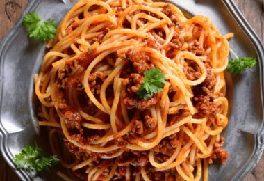Spaghetti à la sauce bolognaise express servis dans une assiette avec parmesan
