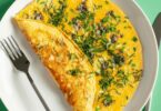 Omelette champenoise au chaource fondant, servie avec persil sur une assiette.