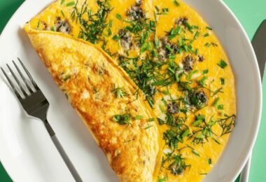 Omelette champenoise au chaource fondant, servie avec persil sur une assiette.