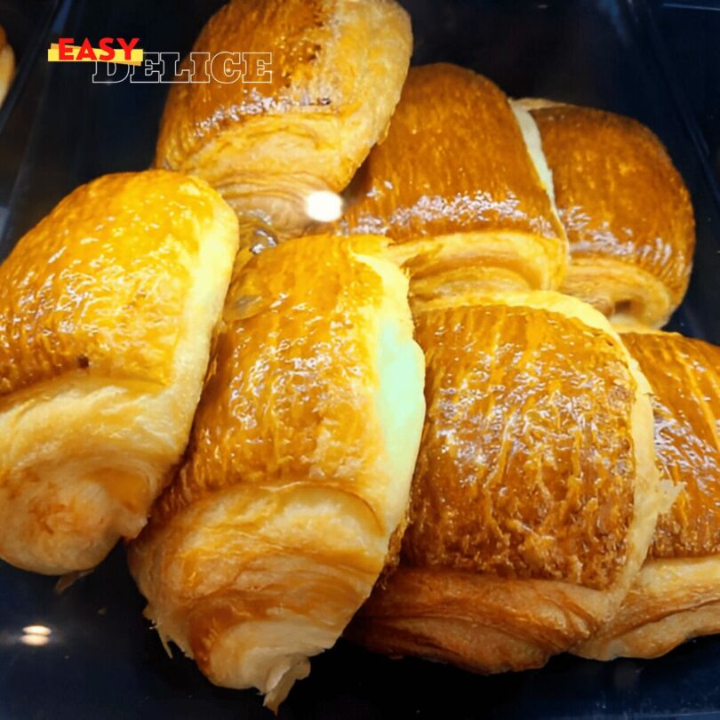 Croissant au chocolat doré et croustillant, garni de chocolat fondant.