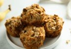Muffins aux fruits secs dorés sur une grille, garnis d’amandes et raisins