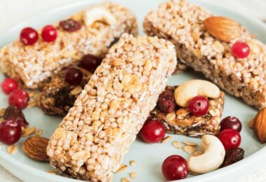 Barres de céréales au riz soufflé avec pépites de chocolat sur une planche en bois.