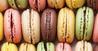 Macarons maison colorés avec ganache au chocolat sur une assiette