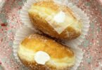 Beignets à la crème pâtissière vanille et chocolat saupoudrés de sucre et cacao sur une assiette.