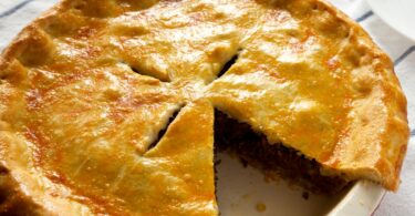 Recette de Tourte à la Viande : Un Plat Réconfortant et Savoureux La tourte à la viande est un classique de la cuisine familiale, combinant une farce riche en saveurs à une pâte croustillante pour un résultat à la fois simple et délicieux. Cette recette tourte viande utilise une garniture de viande hachée parfumée aux légumes et épices, enveloppée dans une pâte brisée ou feuilletée selon vos préférences. Idéal pour un dîner convivial ou un repas à préparer à l’avance, ce plat plaira à tous les amateurs de cuisine maison. Suivez ces étapes pour une tourte viande maison réussie à coup sûr. Pourquoi Choisir cette Recette de Tourte à la Viande ? Une préparation accessible : parfaite pour les cuisiniers débutants ou pressés. Une saveur généreuse : viande, légumes et épices pour un goût équilibré. Une texture parfaite : pâte dorée et croustillante autour d’une farce moelleuse. Une polyvalence : personnalisez la garniture selon vos envies. Ingrédients pour 6 Personnes 500 g de viande hachée (bœuf, porc ou mélange des deux) 1 gros oignon, finement haché 2 gousses d’ail, hachées 1 grosse carotte, râpée 1 poivron rouge, haché 2 cuillères à soupe d’huile d’olive 1 boîte de tomates concassées (400 g) 1 cuillère à soupe de concentré de tomates 1 cuillère à café d’origan séché 1 cuillère à café de cumin en poudre Sel et poivre, selon votre goût 2 feuilles de pâte brisée ou feuilletée (prêtes à l’emploi ou maison) Produits recommandés : Utilisez un moule à tarte, une poêle antiadhésive et des tomates concassées bio disponibles sur Amazon (liens affiliés). Étapes de Préparation 1. Préchauffer le Four Préchauffez votre four à 180°C (thermostat 6 ou 350°F). Préparez un moule à tarte de 24-26 cm de diamètre. 2. Faire Revenir les Aromates Dans une grande poêle, chauffez l’huile d’olive à feu moyen. Ajoutez l’oignon et l’ail hachés, puis faites-les revenir pendant 5 minutes jusqu’à ce qu’ils soient dorés et parfumés, en remuant régulièrement. 3. Cuire la Viande Incorporez la viande hachée dans la poêle. Faites-la dorer pendant 6-8 minutes en l’émiettant avec une cuillère en bois jusqu’à ce qu’elle soit bien cuite et uniformément colorée. 4. Ajouter les Légumes Ajoutez la carotte râpée et le poivron rouge haché. Faites cuire 5 minutes supplémentaires, jusqu’à ce que les légumes commencent à ramollir, en mélangeant bien. 5. Préparer la Sauce Versez les tomates concassées, le concentré de tomates, l’origan, le cumin, le sel et le poivre. Mélangez soigneusement et laissez mijoter à feu doux pendant 10 minutes, jusqu’à ce que la sauce épaississe légèrement et que les saveurs se développent. Laissez tiédir un peu avant de garnir. 6. Monter la Tourte Chemisez le moule avec une feuille de pâte brisée ou feuilletée, en appuyant bien sur les bords pour qu’elle épouse la forme. Versez le mélange de viande uniformément sur la pâte. Recouvrez avec la seconde feuille de pâte, en scellant les bords en les pinçant ou en les roulant ensemble. 7. Finaliser et Cuire Faites 3-4 petites entailles sur le dessus de la pâte avec un couteau pour permettre à la vapeur de s’échapper. Enfournez à 180°C pendant 25 à 30 minutes, jusqu’à ce que la pâte soit dorée et croustillante. Vérifiez la cuisson en observant la coloration. 8. Servir Laissez la tourte à la viande refroidir 5 à 10 minutes avant de la couper en parts. Servez chaude ou tiède, seule ou accompagnée d’une salade verte.