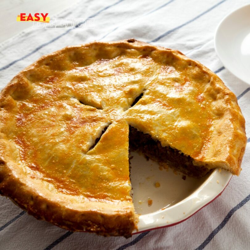 Recette de Tourte à la Viande : Un Plat Réconfortant et Savoureux La tourte à la viande est un classique de la cuisine familiale, combinant une farce riche en saveurs à une pâte croustillante pour un résultat à la fois simple et délicieux. Cette recette tourte viande utilise une garniture de viande hachée parfumée aux légumes et épices, enveloppée dans une pâte brisée ou feuilletée selon vos préférences. Idéal pour un dîner convivial ou un repas à préparer à l’avance, ce plat plaira à tous les amateurs de cuisine maison. Suivez ces étapes pour une tourte viande maison réussie à coup sûr. Pourquoi Choisir cette Recette de Tourte à la Viande ? Une préparation accessible : parfaite pour les cuisiniers débutants ou pressés. Une saveur généreuse : viande, légumes et épices pour un goût équilibré. Une texture parfaite : pâte dorée et croustillante autour d’une farce moelleuse. Une polyvalence : personnalisez la garniture selon vos envies. Ingrédients pour 6 Personnes 500 g de viande hachée (bœuf, porc ou mélange des deux) 1 gros oignon, finement haché 2 gousses d’ail, hachées 1 grosse carotte, râpée 1 poivron rouge, haché 2 cuillères à soupe d’huile d’olive 1 boîte de tomates concassées (400 g) 1 cuillère à soupe de concentré de tomates 1 cuillère à café d’origan séché 1 cuillère à café de cumin en poudre Sel et poivre, selon votre goût 2 feuilles de pâte brisée ou feuilletée (prêtes à l’emploi ou maison) Produits recommandés : Utilisez un moule à tarte, une poêle antiadhésive et des tomates concassées bio disponibles sur Amazon (liens affiliés). Étapes de Préparation 1. Préchauffer le Four Préchauffez votre four à 180°C (thermostat 6 ou 350°F). Préparez un moule à tarte de 24-26 cm de diamètre. 2. Faire Revenir les Aromates Dans une grande poêle, chauffez l’huile d’olive à feu moyen. Ajoutez l’oignon et l’ail hachés, puis faites-les revenir pendant 5 minutes jusqu’à ce qu’ils soient dorés et parfumés, en remuant régulièrement. 3. Cuire la Viande Incorporez la viande hachée dans la poêle. Faites-la dorer pendant 6-8 minutes en l’émiettant avec une cuillère en bois jusqu’à ce qu’elle soit bien cuite et uniformément colorée. 4. Ajouter les Légumes Ajoutez la carotte râpée et le poivron rouge haché. Faites cuire 5 minutes supplémentaires, jusqu’à ce que les légumes commencent à ramollir, en mélangeant bien. 5. Préparer la Sauce Versez les tomates concassées, le concentré de tomates, l’origan, le cumin, le sel et le poivre. Mélangez soigneusement et laissez mijoter à feu doux pendant 10 minutes, jusqu’à ce que la sauce épaississe légèrement et que les saveurs se développent. Laissez tiédir un peu avant de garnir. 6. Monter la Tourte Chemisez le moule avec une feuille de pâte brisée ou feuilletée, en appuyant bien sur les bords pour qu’elle épouse la forme. Versez le mélange de viande uniformément sur la pâte. Recouvrez avec la seconde feuille de pâte, en scellant les bords en les pinçant ou en les roulant ensemble. 7. Finaliser et Cuire Faites 3-4 petites entailles sur le dessus de la pâte avec un couteau pour permettre à la vapeur de s’échapper. Enfournez à 180°C pendant 25 à 30 minutes, jusqu’à ce que la pâte soit dorée et croustillante. Vérifiez la cuisson en observant la coloration. 8. Servir Laissez la tourte à la viande refroidir 5 à 10 minutes avant de la couper en parts. Servez chaude ou tiède, seule ou accompagnée d’une salade verte.