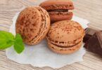 Macarons au chocolat avec ganache brillante empilés sur une assiette blanche