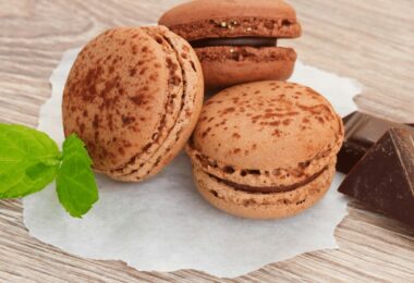 Macarons au chocolat avec ganache brillante empilés sur une assiette blanche