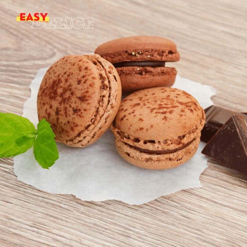 Macarons au chocolat avec ganache brillante empilés sur une assiette blanche