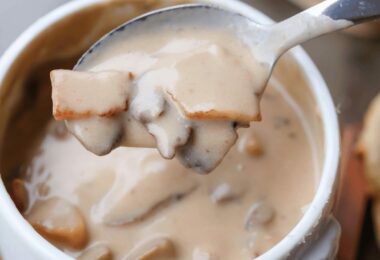 Soupe crémeuse aux champignons dans un bol, garnie de persil