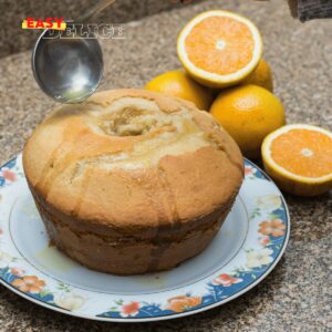 Cake à l’orange moelleux avec un glaçage brillant et des zestes d’orange.