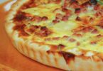 Quiche raclette jambon dorée et fondante, servie avec une salade verte.