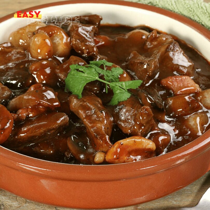 Un plat de bœuf bourguignon mijoté avec des légumes et une sauce onctueuse.