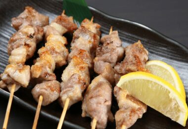 Brochettes de poulet dorées et juteuses, servies avec du citron et des herbes fraîches.