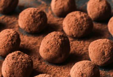 Truffes au chocolat roulées dans du cacao, présentées sur une assiette festive.