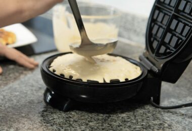 Gaufres dorées et croustillantes servies avec du sucre glace et des fruits frais.