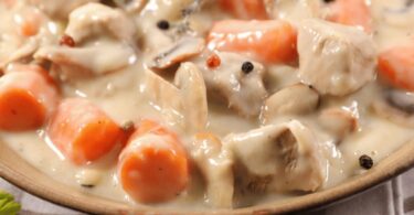 Assiette de blanquette de poulet avec une sauce crémeuse et du riz blanc.