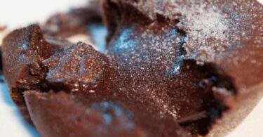 Soufflé au chocolat bien gonflé avec une croûte légèrement craquelée et un cœur fondant.